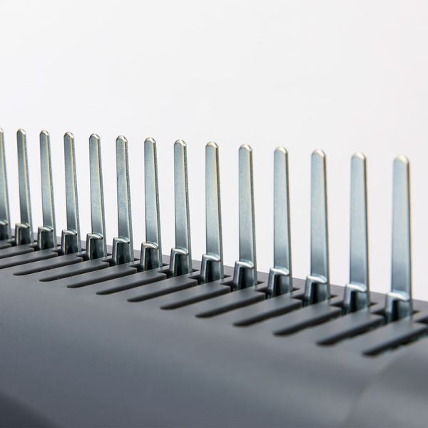 Close-up of binding machine comb on a light gray background