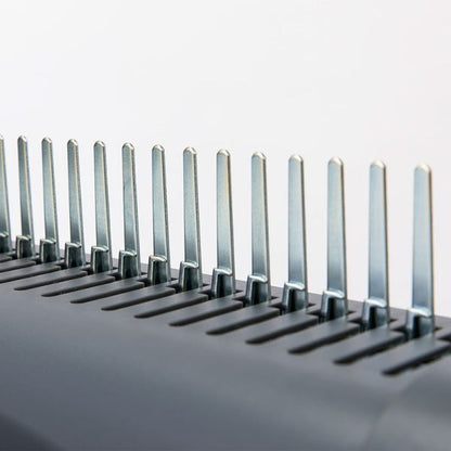 Close-up of binding machine comb on a light gray background