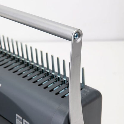 Close-up of a binding machine with metal comb teeth on a white background
